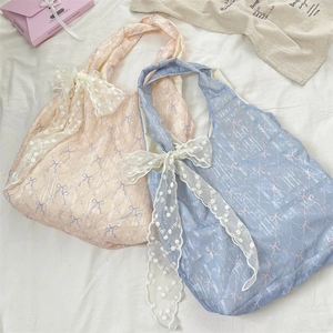 Détail de sacs fourre-tout en toile avec broderie en dentelle en rose et bleu clair
