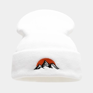 Gros plan détaillé de la broderie montagne et soleil sur un bonnet en maille blanche