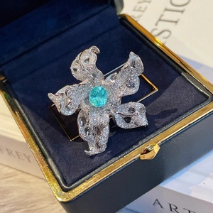 Macro shot of silver flower brooch with turquoise and crystals in a luxury jewelry box