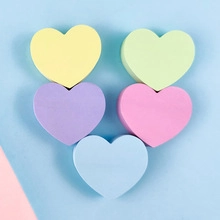 Top view of five colorful heart-shaped makeup sponges on a soft light blue background