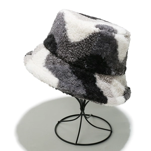 Detail of soft plush bucket hat showing grey and white patchwork fuzzy faux fur texture