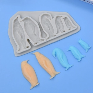 Grey penguin silicone mold with finished 3D penguin figures for cake DIY baking