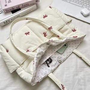 Interior view of quilted tote bag with red bow embroidery and star pattern lining