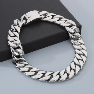 Detailed view of bold silver Cuban link chain with secure clasp on luxury packaging