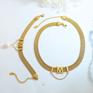 Gold mesh jewelry set with letter M pendant, freshwater pearl detail and K18 hallmark