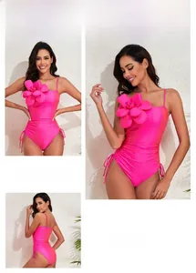 Detail of fuchsia one-piece swimsuit with 3D floral accent and side drawstring ties