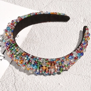 Close-up of handmade baroque headband with colorful crystals on thick black fabric