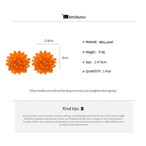 Detail view of orange floral cluster earrings with dimensions 2.4cm by 3cm and silver pins