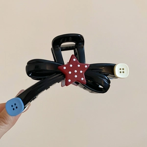 Detail of creative acrylic star and button bow hair claw clip with black glossy finish