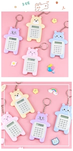 Close-up of cute cartoon bear mini calculators with keychains in pastel colors