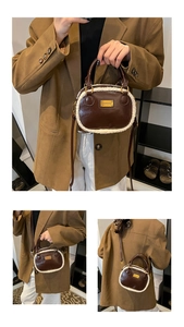 Detail view of the brown leather Boston bag with white faux fur trim and gold metal logo