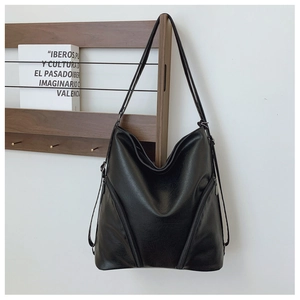Detail of black glossy PU leather backpack featuring zipper accents and soft texture