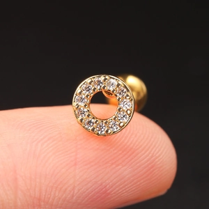 Macro shot of gold stainless steel stud earring with shimmering round zircon inlay detail