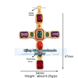 Dettaglio del ciondolo a croce in rame dorato con cristalli di zirconia multicolore