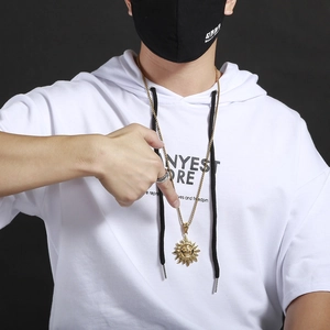 Male model wearing golden sun face pendant necklace with tribal skull details