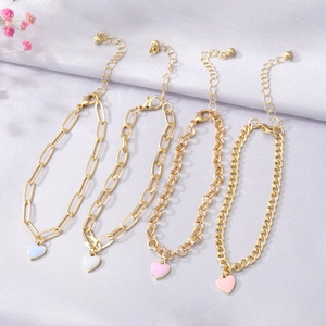 Lot de 4 bracelets dorés avec breloques cœurs en émail blanc et rose sur tissu en soie