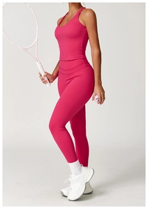 Dettaglio del set yoga rosa con reggiseno sportivo incrociato e leggings compressivi a vita alta