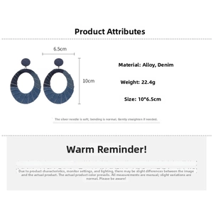 Detail of large oval denim fabric earrings with navy blue alloy rings and texture