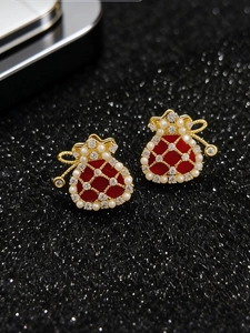 Detail of red enamel lucky bag earrings with white pearls and sparkling zircons