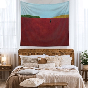 Minimalist bohemian wall tapestry featuring red abstract landscape art in a cozy bedroom