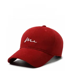 Detailed view of red cotton baseball cap with white 'me' embroidery on white background