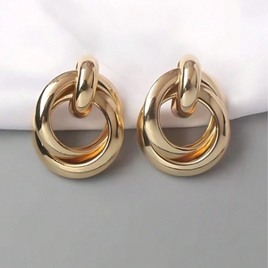 Polished gold geometric double ring drop earrings in a minimalist jewelry design style