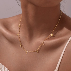 Collier élégant en acier inoxydable doré avec breloques étoile et lune porté par un modèle