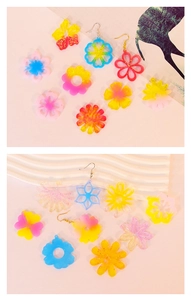 Flat lay of colorful DIY floral resin earrings and flower-shaped snowflake pendants