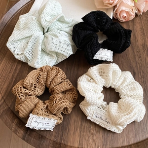 Détail de la dentelle et des étiquettes tissées sur quatre chouchous élégants colorés