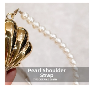 Detailed view of luxury pearl shoulder strap with elegant gold shell-shaped metal clasp
