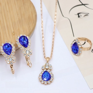 Detail view of blue water drop jewelry set with necklace rings and earrings in gold finish