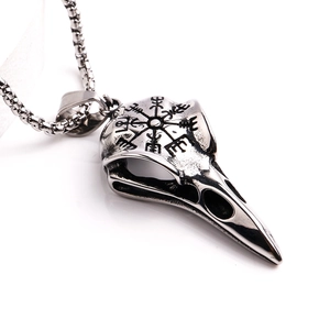 Detailed view of vintage viking stainless steel raven skull pendant with engraved symbols