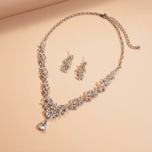 Macro view of silver floral necklace and teardrop crystal earrings jewelry set