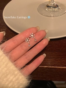 Gros plan de boucles d'oreilles flocon en argent avec pendentifs portées lors d'un dîner