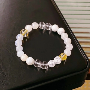 Macro shot of white crystal and rutilated quartz beads on a minimalist luxury bracelet