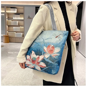 Detail of blue canvas tote bag featuring elegant lotus and dragonfly embroidery patterns