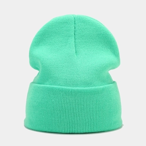 Close-up of mint green knitted beanie showing fine vertical ribbed texture and folded cuff