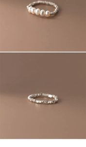Macro detail of irregular silver texture and white pearls on a minimalist handmade ring