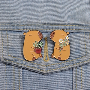Set of cute capybara enamel pins with flower and plant on blue denim jacket