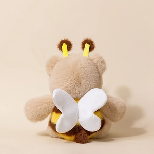 Back view of a cute plush bear in a bee costume with soft wings and brown stripes