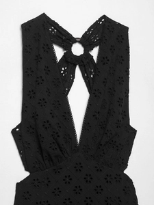 Detail of black eyelet embroidery with deep V-neck and halter neck open back design
