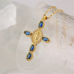 Détail du pendentif croix religieuse dorée avec cristaux bleus et halo de zircone