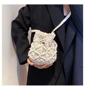 Close-up of white handmade woven cotton bag with wooden bead drawstring detail
