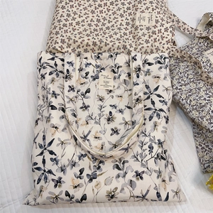 Flat lay detail of floral canvas tote bag featuring an elegant sewn-on rectangular label