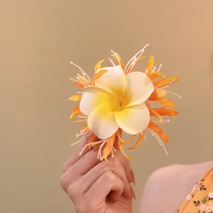 Detailaufnahme einer frischen weiß-gelben Plumeria-Stoffblumen-Haarklammer für Damen.