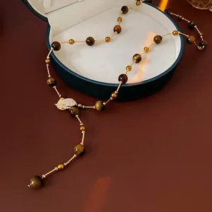 Tiger eye stone long tassel necklace with zircon leaf pendant on jewelry box