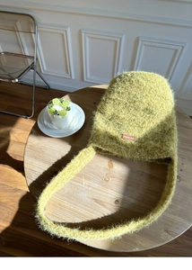 Detail der weichen gelb-grünen Plüschstrick-Umhängetasche auf einem Tisch