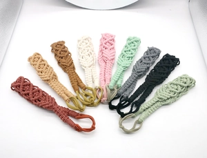 Detailed view of nine handmade woven cotton ropes in various colors with ring loops
