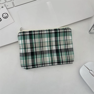 Gros plan sur la pochette à carreaux vert et noir avec fermeture éclair pour clés