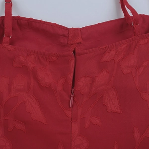 Detail of red floral textured fabric featuring a seamless hidden back zipper closure